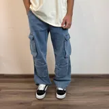 Pantalón jean color beige, de corte holgado y estilo cargo, con múltiples bolsillos laterales.