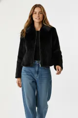 Chaqueta corta negra de piel sintética con cuello clásico, cierre frontal con cremallera y mangas largas.