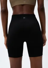 Short deportivo negro de tiro alto, corte ajustado y tejido acanalado.