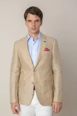 Saco de lino color beige, corte slim fit, con solapa de muesca, cierre de dos botones, bolsillo en el pecho y dos bolsillos delanteros con solapa. Medio forro.