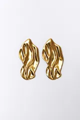 Aros colgantes de acero inoxidable color dorado con forma orgánica irregular.