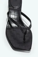 Sandalias de dedo negras con textura de cocodrilo, punta angular, tiras finas sobre el empeine y taco kitten.