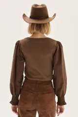 Top negro de calce al cuerpo con escote cuadrado amplio. Mangas largas abullonadas con puños elastizados.