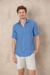 Camisa azul de lino con manga corta, cuello clásico y corte recto.
