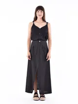 Musculosa negra con escote en V y botones frontales. Los tirantes son ajustables con hebillas metálicas.