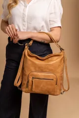 Cartera mochila color tostado, símil cuero, con compartimiento principal amplio y bolsillos frontales con cierre. Tiene correas ajustables para usar como mochila y asa superior para llevar al hombro.