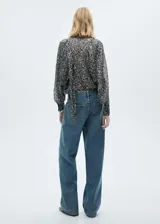 Blusa de manga larga con estampado animal print en tonos grises y blancos. Tiene cuello redondo con lazo para atar.
