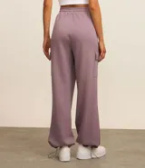 Pantalón deportivo color lila, confeccionado en microfibra pesada con viscosa certificada. Cuenta con cintura elástica ajustable, bolsillos cargo laterales y ajuste en el bajo.