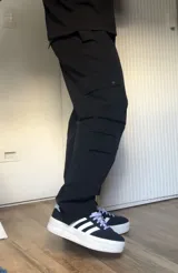 Pantalón cargo negro de corte recto con múltiples bolsillos con solapa y botón a presión.