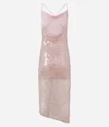 Vestido midi de malla con lentejuelas plateadas, escote recto y tirantes finos cruzados en la espalda. Presenta un forro corto que deja ver la transparencia de la malla con lentejuelas en la parte inferior, creando un bajo asimétrico.