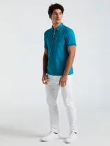 Polo azul con cuello tipo camisero, mangas cortas con ribete en contraste y bolsillo de parche en el pecho.