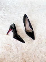 Zapato de tacón alto Iara, color negro charol, con punta fina y suela roja. Fabricado en cuero.