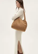 Vestido largo de punto de canalé color crudo, con cuello alto y mangas largas.