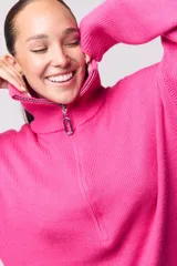 Sweater tejido color fucsia, con cremallera en el cuello y diseño suelto.