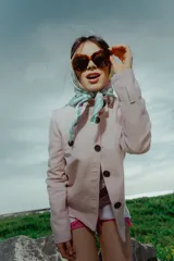 Chaqueta rosa con cuello elevado y cierre frontal con botones marrones.