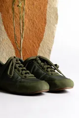 Zapatillas deportivas verde oliva con cordones y suela marrón.