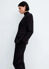 Blazer negro entallado con cuello de pico y solapa con muesca, manga larga, hombros estructurados, dos bolsillos de ribete delanteros, pinzas, abertura posterior y forro interior.