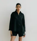 Camisa negra de lino con corte recto, cuello clásico, mangas largas y abertura en los laterales.