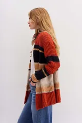 Cárdigan tejido de calce holgado, mangas largas y diseño a rayas horizontales en tonos naranja, negro, beige y blanco.
