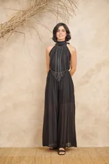 Mono negro de seda fluida, con corte amplio, espalda abierta y cuello halter que se ata con una moña.