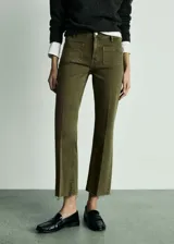 Pantalón de jean verde militar, de tiro medio, corte acampanado y largo cropped. Presenta bolsillos de parche delanteros y traseros, trabillas y terminación desflecada.