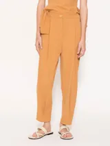 Pantalón baggy color ocre, confeccionado en poplin 4way con largo hasta los tobillos. Presenta diseño con tabla en cintura y ruedo, bolsillos laterales escondidos, elástico en la espalda y cierre con broche, cierre y botón interno.