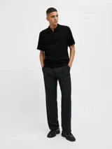 Polo negro de punto con cierre de cremallera, cuello polo y mangas cortas.