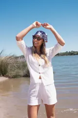 Conjunto blanco de camisa de manga 3/4 con botones y shorts.