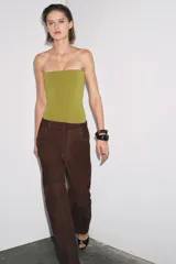Body bandeau color verde oliva confeccionado en tejido elástico, con escote recto y hombros descubiertos. Cierre inferior con botones a presión.