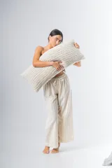 Pantalón de algodón color crudo con rayas verticales finas en beige, corte recto, cintura con elástico y detalle de puntilla en cintura y ruedo.