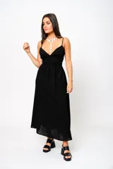 Vestido largo negro con escote en V, tirantes finos y espalda baja. Tiene frunces en la cintura que realzan la silueta.