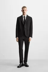 Pantalón de vestir negro slim fit, confeccionado en tejido con viscosa. Cuenta con bolsillos frontales y traseros de vivo. El cierre es frontal con cremallera y botón.