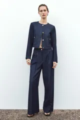 Pantalón de tiro alto color azul denim, con pinzas delanteras, bolsillos frontales, pernera ancha y pespuntes combinados a contraste en color beige.