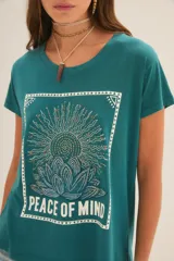 Remera negra de algodón y modal con estampa de un girasol y la frase "Peace of Mind".