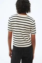 Remera de punto fino color crema con rayas horizontales negras, de manga corta y cuello redondo.