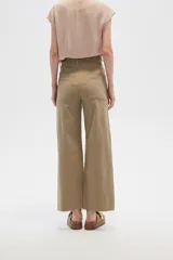 Pantalón de jean color beige, de corte flare y tiro alto, con terminación desflecada.
