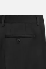 Pantalón de vestir negro de lana, corte recto, con bolsillos laterales y traseros de ojal con botón.
