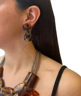 Aros colgantes con forma geométrica, con pieza superior cuadrada y pieza inferior triangular, con diseño carey en tonos negro, marrón y amarillo.