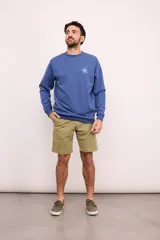 Sudadera azul de cuello redondo, manga larga y puños y dobladillo acanalados. Presenta un estampado de sol en color blanco en el lado izquierdo del pecho.