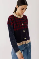 Cárdigan marrón con diseño de rombos en tonos rojizos y beige. Tiene cuello redondo, cierre frontal con botones y mangas largas con puños acanalados.