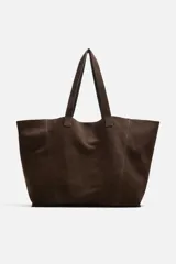 Bolso tipo shopper marrón de cuero serraje, con doble asa de hombro y compartimento principal abierto con bolsillo interior con cierre.
