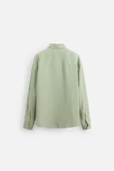 Camisa verde claro de corte relaxed fit confeccionada en tejido con mezcla de modal. Tiene cuello italiano, manga larga con puños abotonados, bolsillo de parche en el pecho y cierre frontal abotonado.