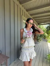 Falda corta de lino color beige, con detalle fruncido en todo el cuerpo y ruedo con volado amplio. Tiene cintura elástica.