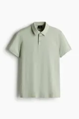 Remera polo verde claro en tejido de punto de algodón liviano, de corte ajustado, con cuello clásico, tapeta de botones y mangas cortas.