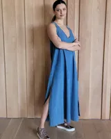 Vestido largo azul melange de corte imperio, con escote en V y breteles finos. Presenta una abertura lateral en la falda.