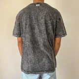 Remera gris con efecto acid wash y corte regular.