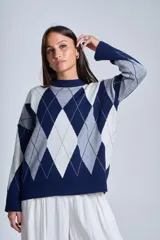 Sweater de punto con diseño de rombos en tonos beige y blanco, cuello redondo y corte holgado.