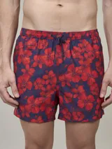 Short de baño azul marino con estampado de flores rojas, cintura elástica y cordón ajustable. Interior de malla.