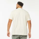 Camiseta de manga corta color crema con cuello henley y tres botones. Corte recto y holgado.