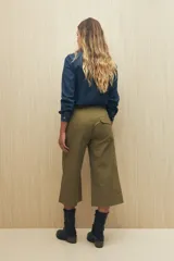 Pantalón capri color beige de algodón, con corte acampanado, bolsillos laterales tipo cargo y cintura con cordón ajustable.